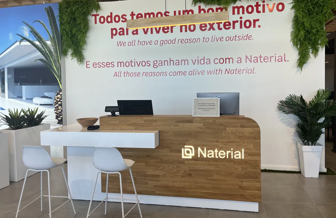 Recepție din lemn de stejar cu perete verde într-un showroom de mobilier de grădină